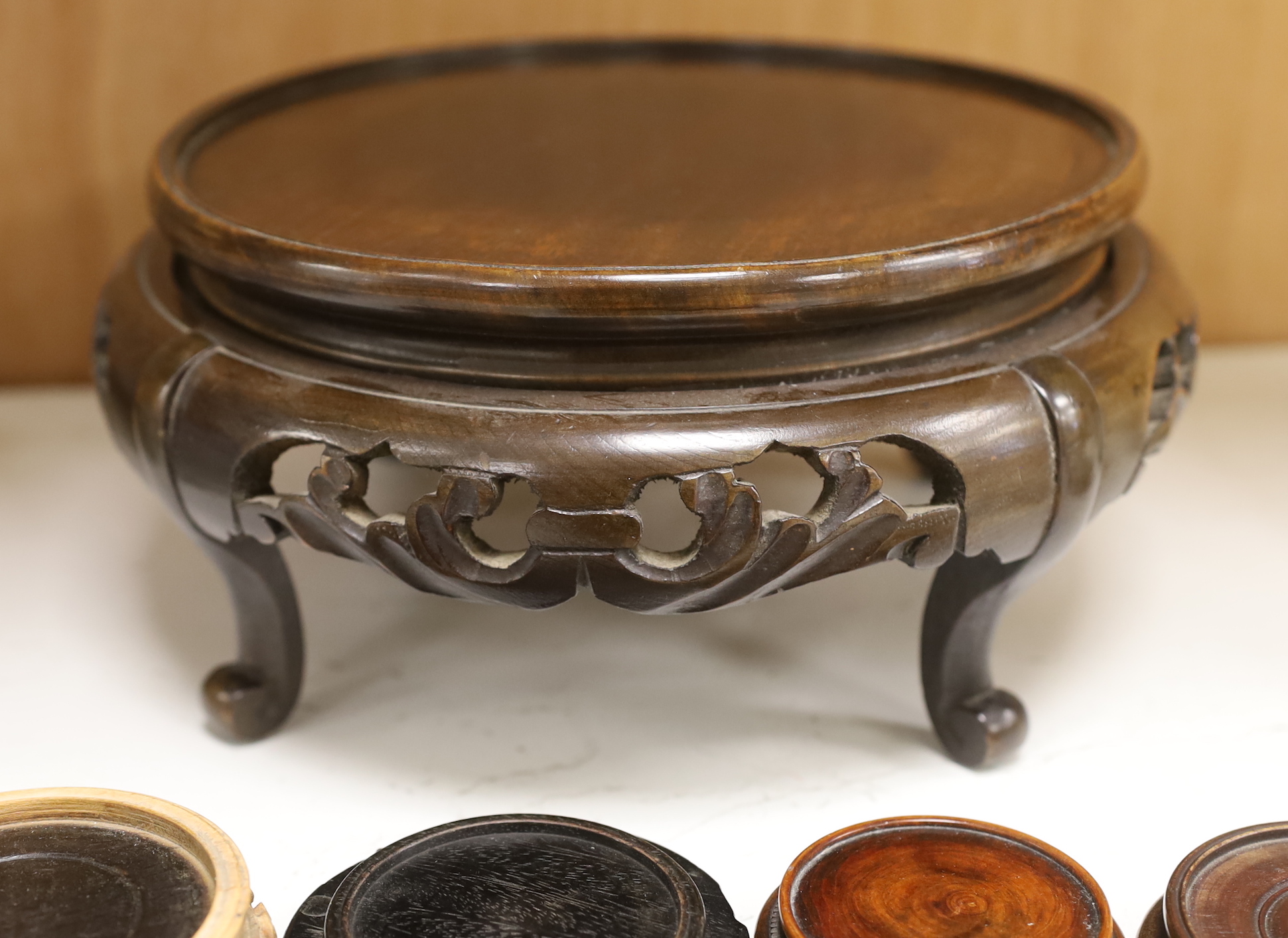 Two large Chinese or Japanese hardwood stands and four others, largest 11cm high